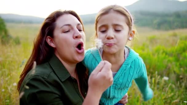 Madre y niña soplando diente de león — Vídeos de Stock