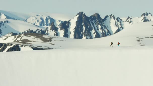 Escaladores que atravessam uma cordilheira coberta de neve — Vídeo de Stock