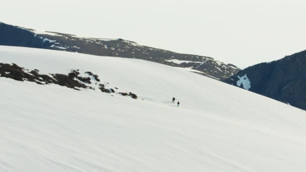 Альпинисты, пересекающие снежную горную цепь — стоковое видео