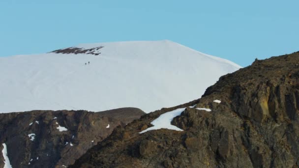 Pessoas escalando uma montanha coberta de neve — Vídeo de Stock