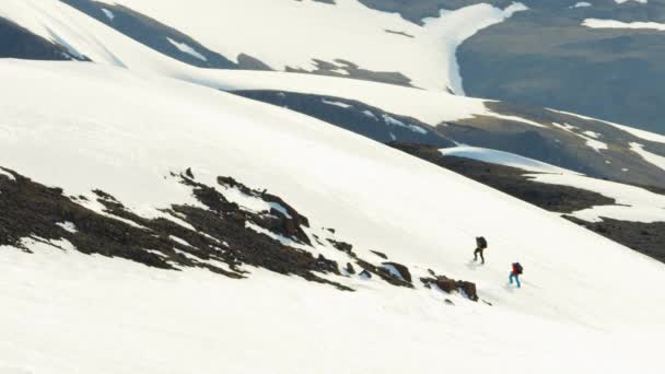 Gente escalando una montaña cubierta de nieve — Vídeo de stock