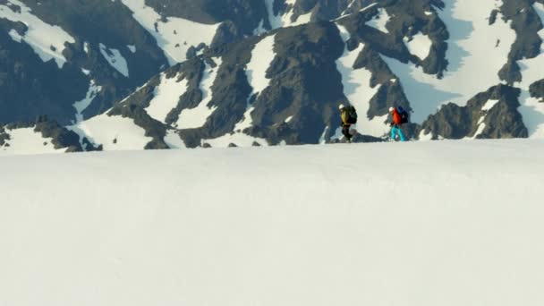 Люди карабкаются на заснеженные горы — стоковое видео