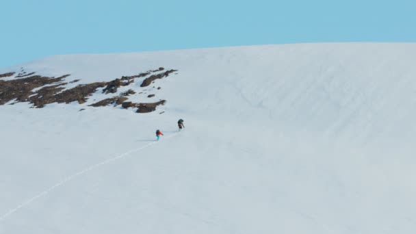 Escaladores que atravessam uma cordilheira coberta de neve — Vídeo de Stock