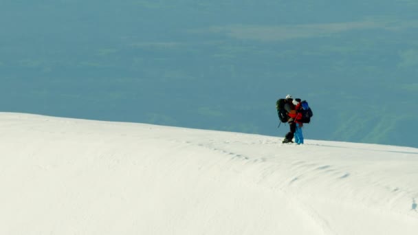 Pessoas escalando uma montanha coberta de neve — Vídeo de Stock