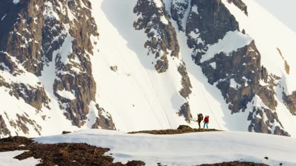 Люди піднімаються на снігову криту гору — стокове відео
