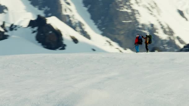 Люди піднімаються на снігову криту гору — стокове відео