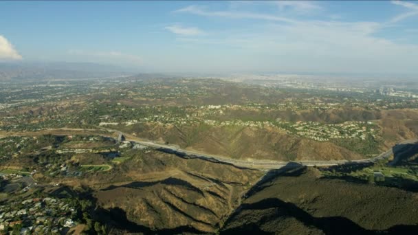 Aerial view freeway through mountain ranges Los Angeles — Stockvideo
