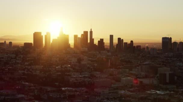 Güneşin parlamasıyla Los Angeles 'ın ortasındaki havadan gün doğumu görüntüsü. — Stok video