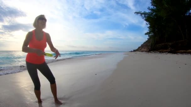 Mujer mayor disfrutando jugando Frisbee al amanecer Bahamas — Vídeos de Stock