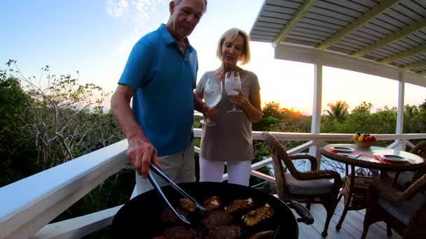 Seniorer förbereder grill på däck vid solnedgången Bahamas — Stockvideo