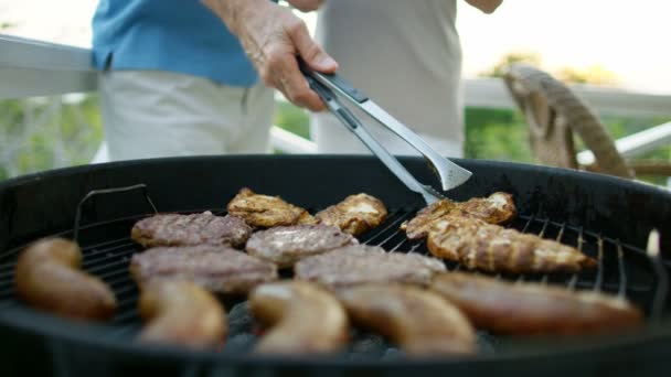 Mannelijke en vrouwelijke senioren bereiden barbecue buiten Bahama 's — Stockvideo