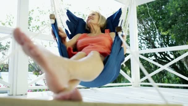 Mature female enjoying retirement in hammock outdoor Bahamas — Stock Video