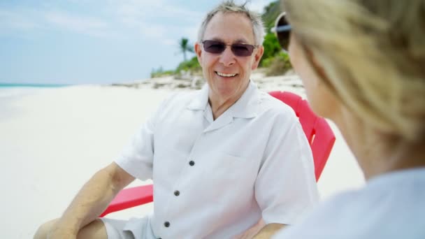 Pensioneret par i røde stole på stranden Bahamas – Stock-video