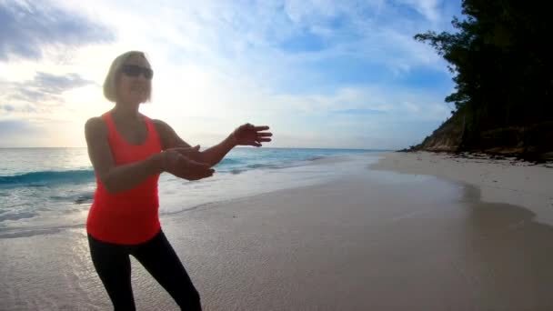 На пляжі Багамські острови відпочиває жінка, яка грає в фризбі. — стокове відео