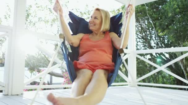 Senior žena relaxace v houpací síti na terase Bahamy — Stock video