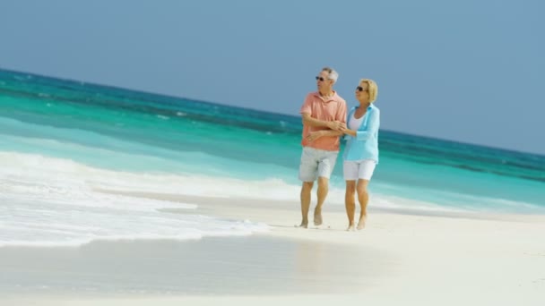 Mannelijke en vrouwelijke senioren wandelen op het strand Bahama 's — Stockvideo