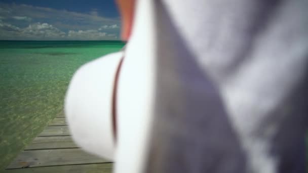 Красива жінка з білим капелюхом на пристані Багамських островів. — стокове відео
