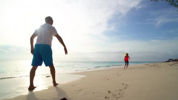 Fit senior couple enjoying Frisbee on beach Bahamas — Stock Video