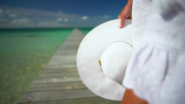 Kobieta na molo na plaży z kapeluszem Bahamy — Wideo stockowe