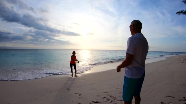 Silhuett av pensionerat par spelar Frisbee vid soluppgången — Stockvideo