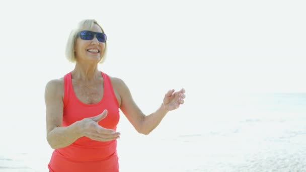 Mosolygó idősebb amerikai nő játszik frizbi játékok Bahama-szigetek — Stock videók