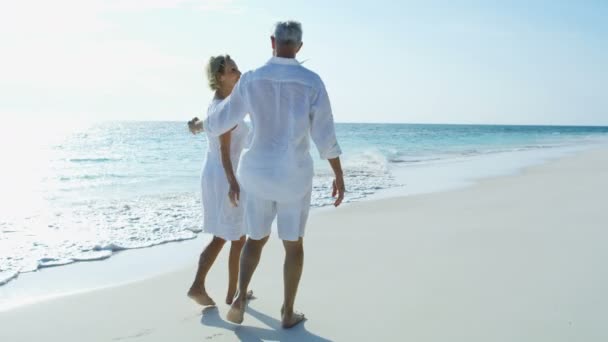 Idosos masculinos e femininos caminhando na praia Bahamas — Vídeo de Stock