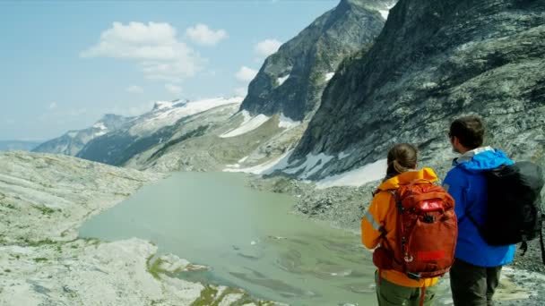 Jeunes Randonneurs Heli Couple Touristique Caucasien Regardant Lac Glaciaire Montagne — Video