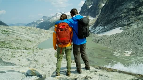 加拿大高山上观赏冰川湖水瀑布的白人男女青年徒步旅行者 — 图库视频影像