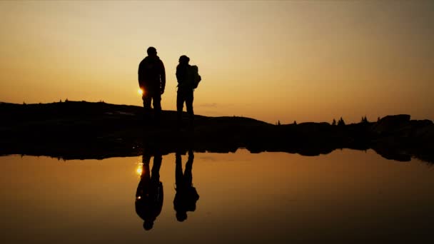 健康的なアクティブな若者のシルエット極端な屋外山の荒野で日没時に湖の近くのレジャーハイキング ブリティッシュコロンビア — ストック動画