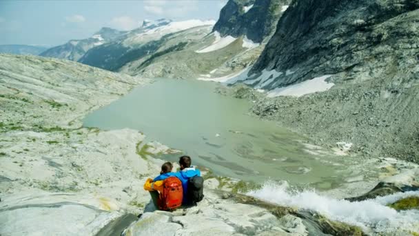 活跃的人们在高山上徒步旅行 坐在冰湖瀑布边 在夏日阳光下悠闲自在 不列颠哥伦比亚省 — 图库视频影像