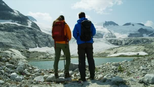 健康活跃的年轻人在不列颠哥伦比亚省冰川湖畔的极端户外山地野外徒步旅行 — 图库视频影像