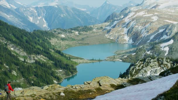 在加拿大冰川湖附近的风景秀丽的山崖边散步的白人男性年轻白人男性 — 图库视频影像