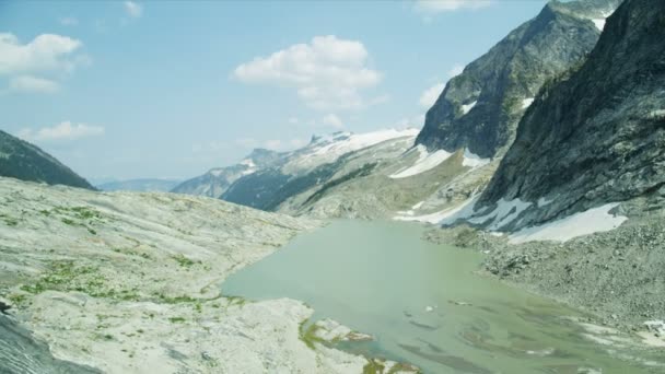 在冰川湖附近的风景秀丽的高山上徒步旅行的男女白人青年观光客 — 图库视频影像