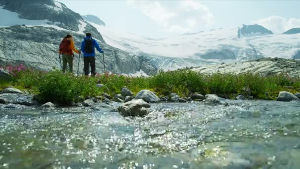 日差しの中で氷河の流れにリラックスして極端な高い山の地形でアクティブな人々のレジャーハイキング ブリティッシュコロンビア — ストック動画