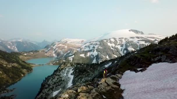 夏に氷河の山の湖を見る若い男性ヘリハイカー白人観光客カナダブリティッシュコロンビア — ストック動画