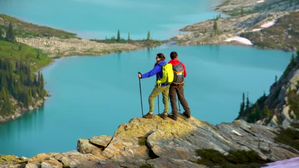 在加拿大冰川湖附近的风景秀丽的山上徒步旅行的白人男性年轻女性 — 图库视频影像