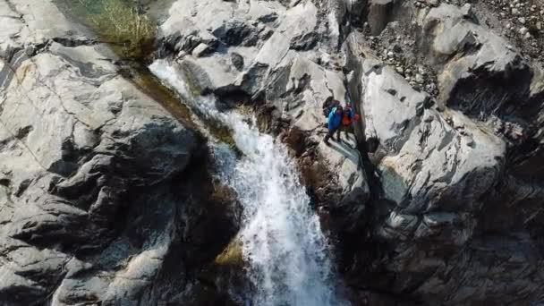 位于加拿大不列颠哥伦比亚省冰川瀑布附近的白种人远足年轻夫妇的空中俯瞰 — 图库视频影像