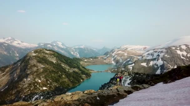 在加拿大冰川湖附近的风景秀丽的群山中 空中游览成功的海莉徒步旅行男性白人年轻女性旅行者 — 图库视频影像