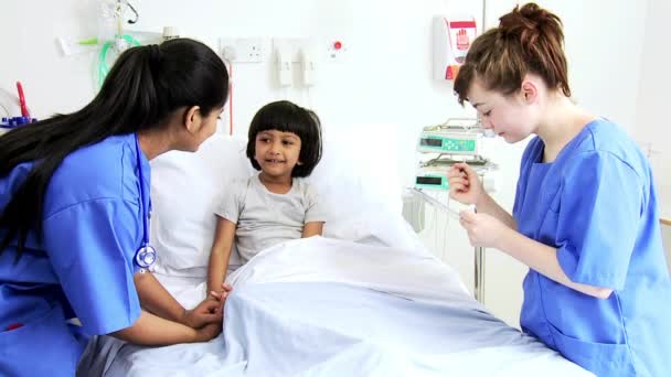 Девочка, получающая медицинскую помощь от медсестер — стоковое видео