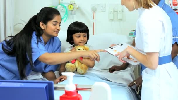 Girl clutching teddy bear in hospital bed — Stock Video