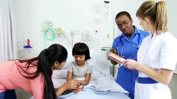 Enfermeiras de crianças étnicas femininas cama de hospital de menina — Vídeo de Stock