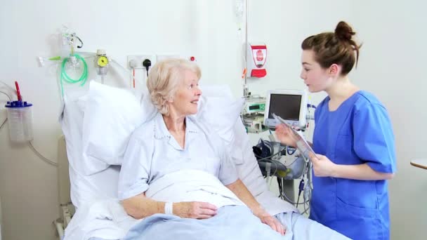 Enfermeras revisando progreso Paciente de edad avanzada Cama de hospital — Vídeos de Stock