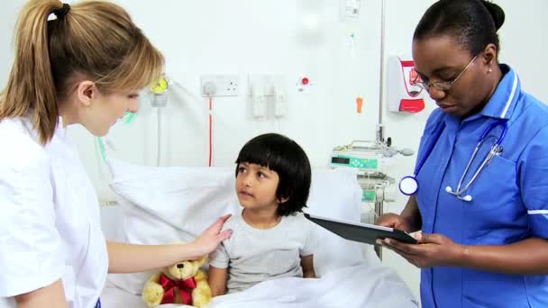 Personal de enfermería multiétnico que registra el tratamiento del paciente infantil — Vídeo de stock