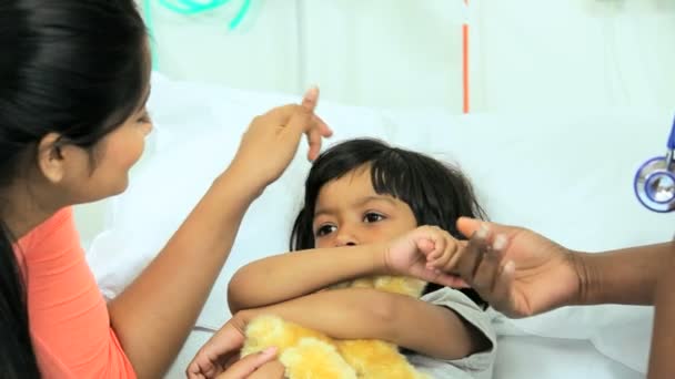 Girl clutching teddy bear in hospital bed — Stock Video