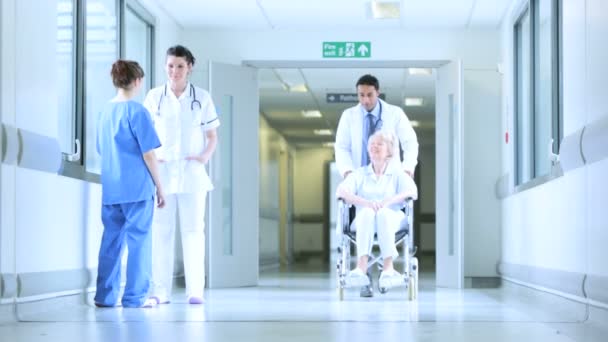 Multi-etnische personeel bewegende patiënten ziekenhuis corridor — Stockvideo