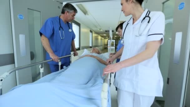 Медсестринский персонал медленного движения толкает больничную койку — стоковое видео