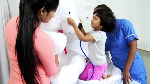 Patient playing with stethoscope and teddy bear — Stock Video