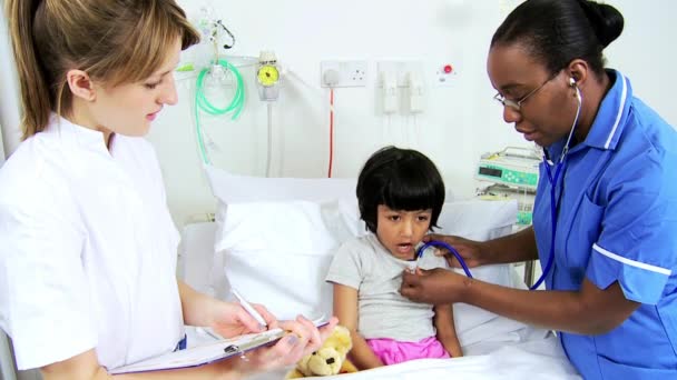 Multi-ethnische Pflegekräfte erfassen Behandlung von Kinderpatienten — Stockvideo