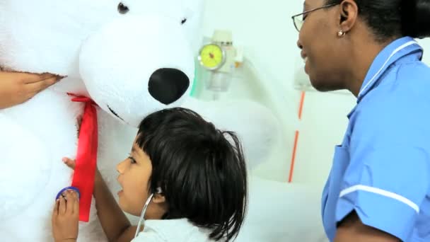 Niño paciente jugando con estetoscopio y osito de peluche — Vídeo de stock