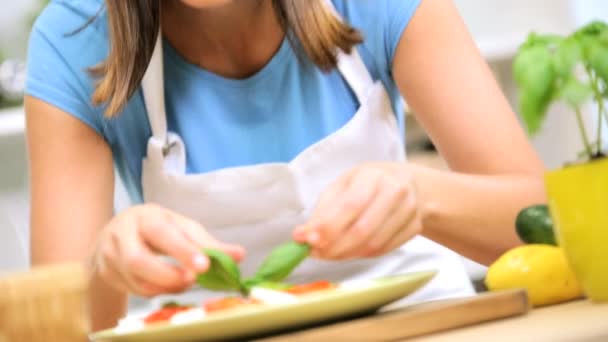 Girl adding basil to buffalo mozzarella — Stock Video